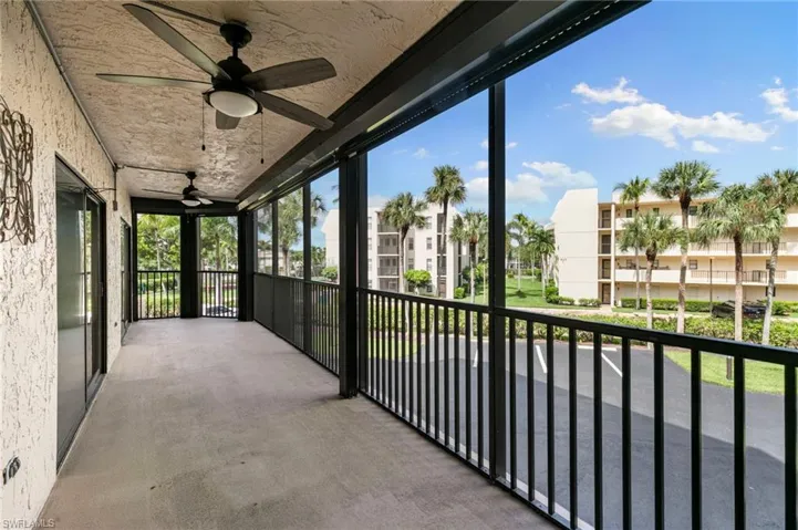 Unfurnished sunroom with ceiling fan and a balcony