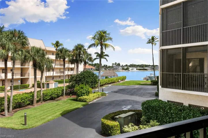 Surrounding community with a sunroom, a water view, and a yard