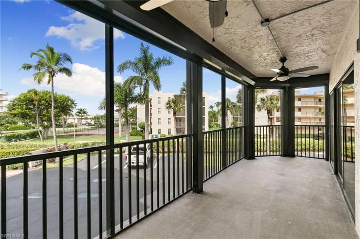 Unfurnished sunroom featuring ceiling fan and a balcony