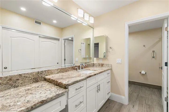 Bathroom featuring vanity, light wood-type flooring, and recessed lighting