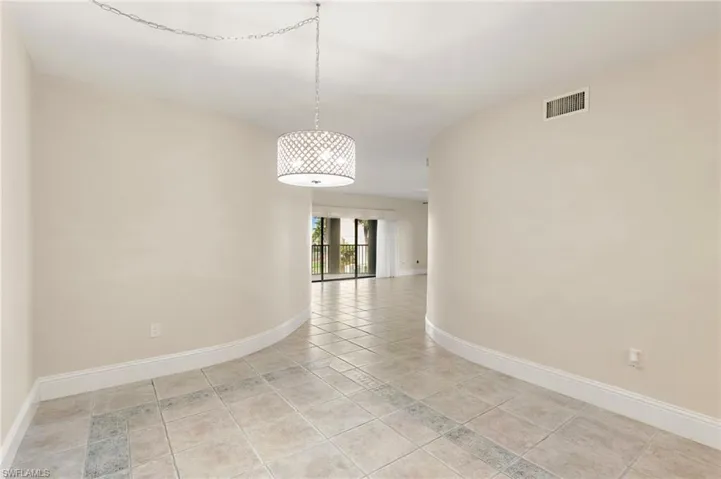 Empty room with baseboards and light tile patterned floors