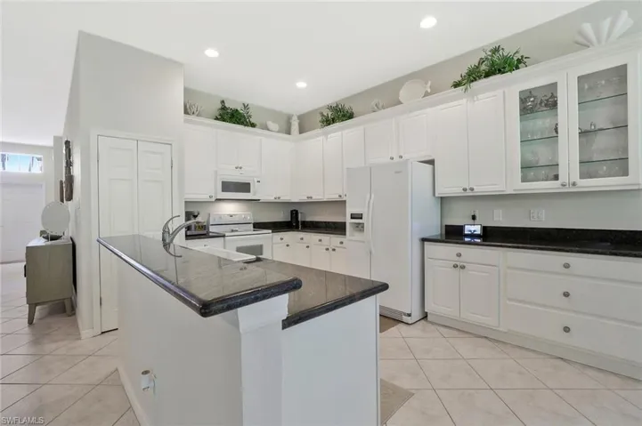 Kitchen featurin, glass insert cabinets, granite and breakfast bar