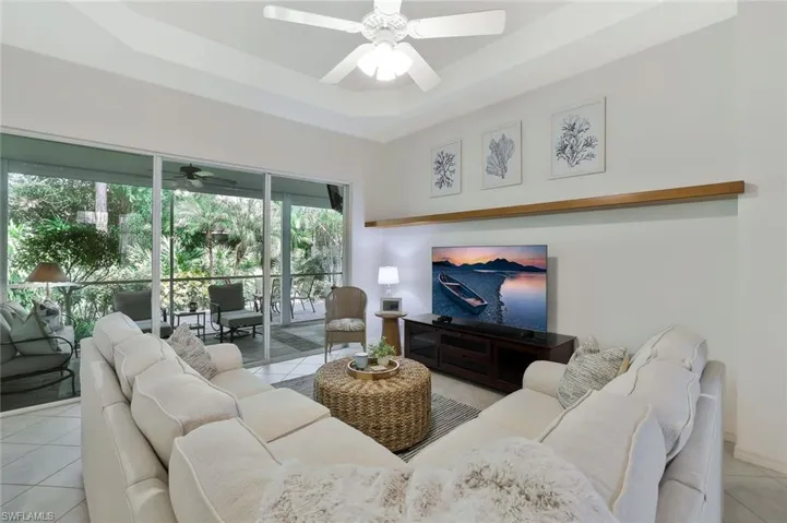 Living area featuring a ceiling fan, sliders to lanai