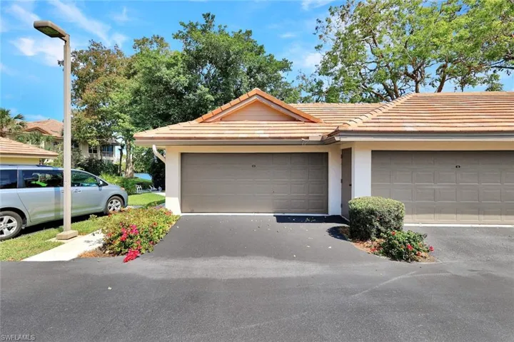 Large two-car garage with additional parking spaces conveniently located directly beside it.