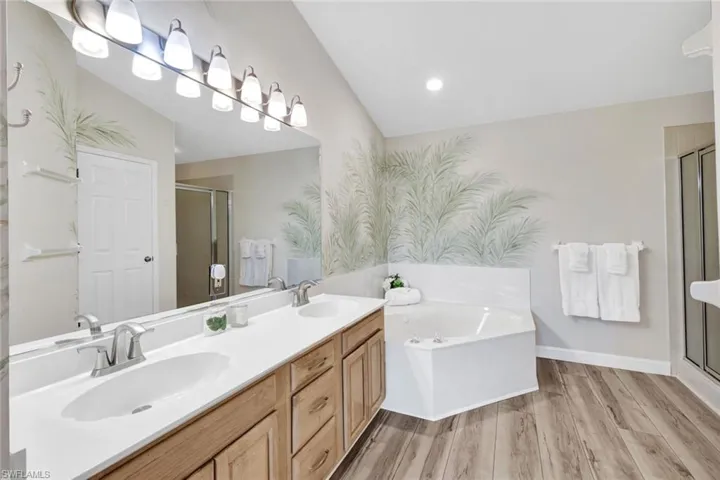 The primary bathroom features dual vanities with generous counter space and a relaxing soaking tub, creating a comfortable, spa-like retreat.
