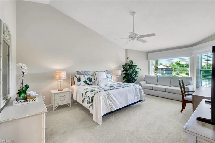 A spacious primary suite surrounded by windows, filled with natural light and a bright, open ambiance.