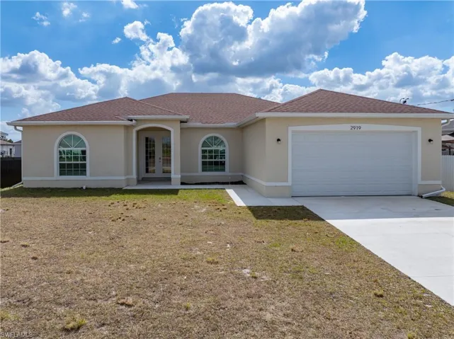 Mediterranean / spanish-style home with french doors, stucco siding, driveway, and an attached garage