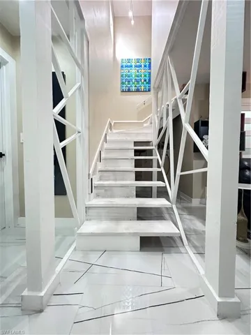 Staircase featuring marble finish flooring