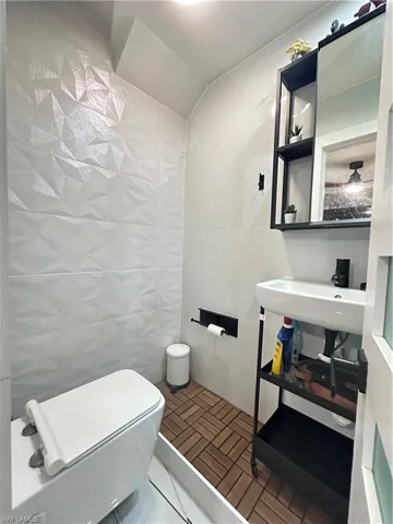Bathroom with tile walls and vaulted ceiling