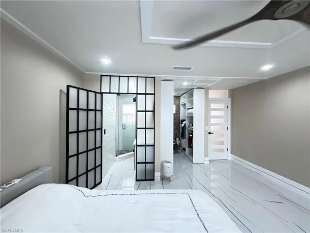 Bedroom with a walk in closet, marble finish floors, recessed lighting, ensuite bath, and french doors