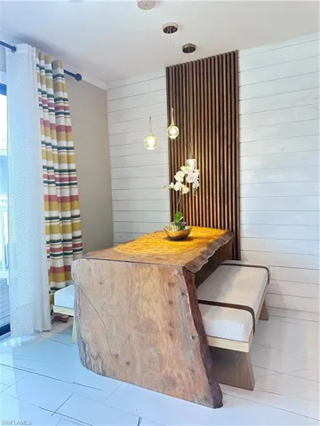 Dining area featuring wooden walls and tile patterned floors