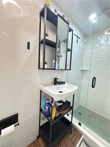 Bathroom with a stall shower and a sink