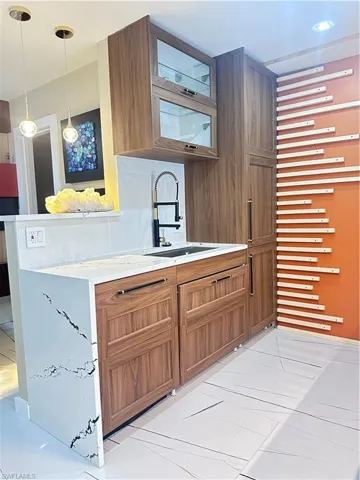Kitchen featuring brown cabinets, light countertops, and hanging light fixtures
