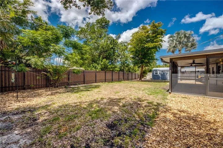 View of yard featuring a sunroom and ceiling fan