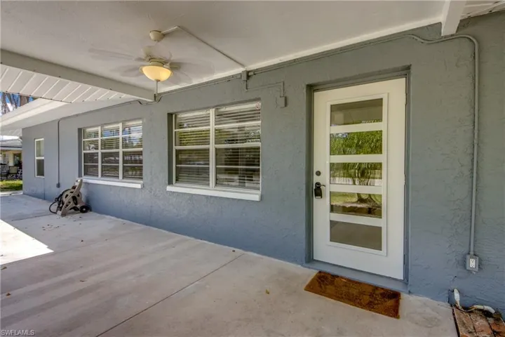 Property entrance featuring a ceiling fan, stucco siding, and a patio