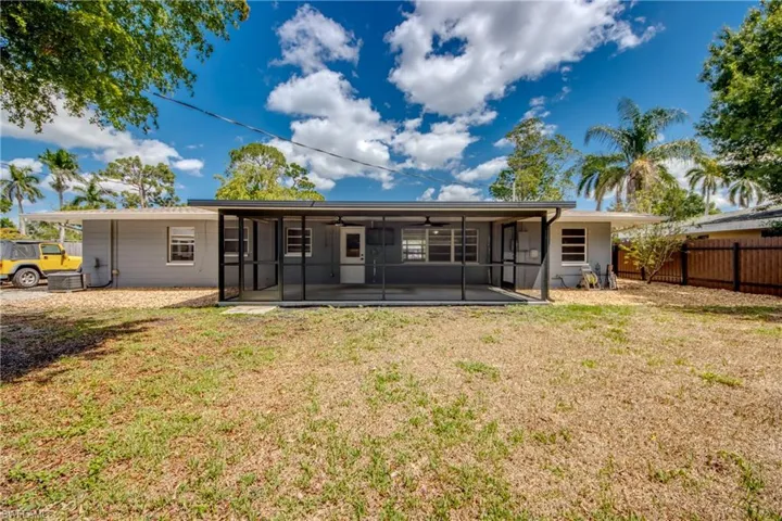 Rear view of house with a sunroom, ceiling fan, and central AC unit