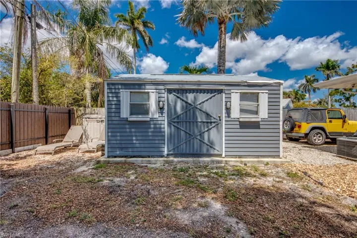View of shed featuring fence and cooling unit