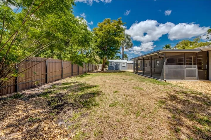 View of yard featuring a sunroom and an outdoor structure