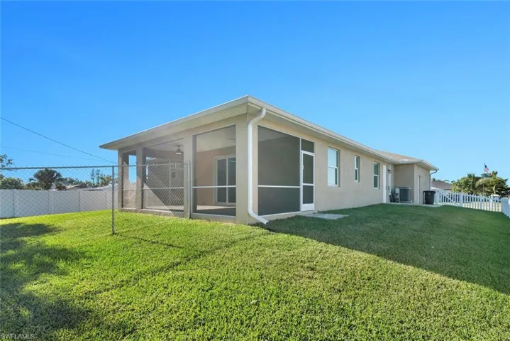 Rear view of house with a yard and a sunroom