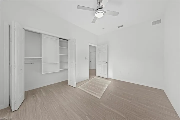 Unfurnished bedroom with light hardwood / wood-style flooring, a closet, and ceiling fan