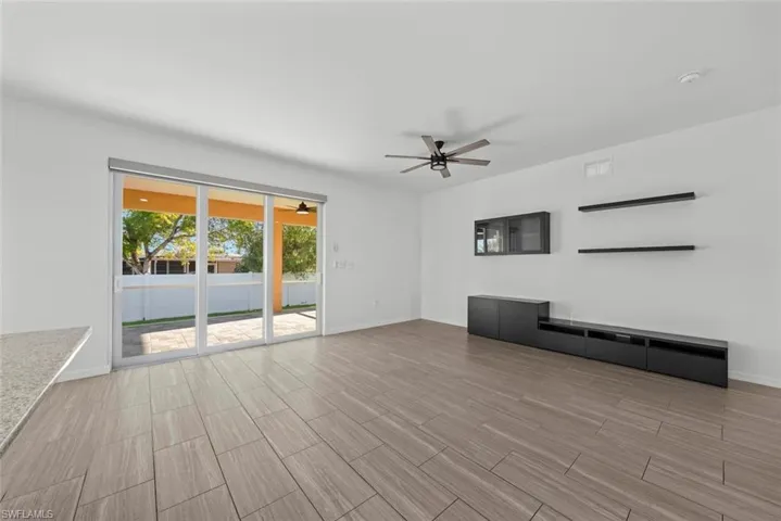 Unfurnished living room featuring ceiling fan