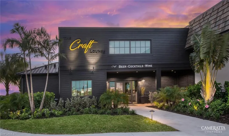 Modern building facade with dark horizontal siding, prominent illuminated signage, and a distinctive cedar shake roofline