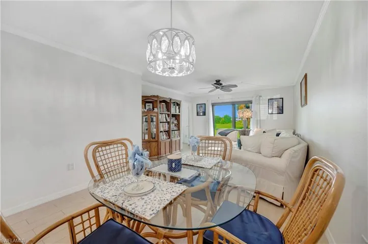 Dining space with crown molding and ceiling fan with notable chandelier