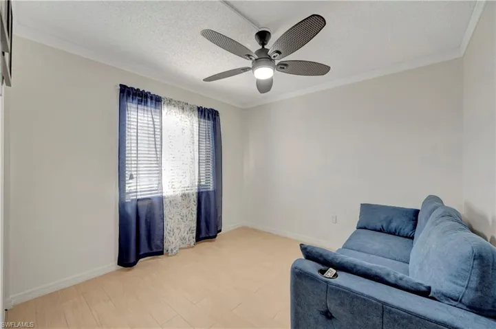 Living area featuring crown molding, a textured ceiling, light hardwood / wood-style flooring, and ceiling fan
