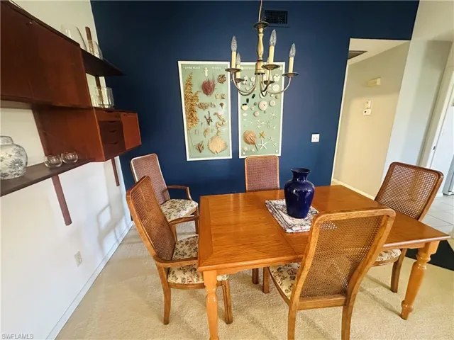 Dining space featuring a chandelier and baseboards