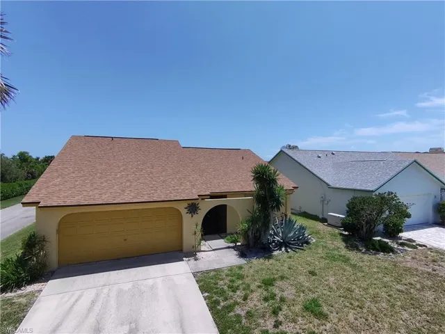 View of front of house featuring driveway, stucco siding, an attached garage, a shingled roof, and a front lawn