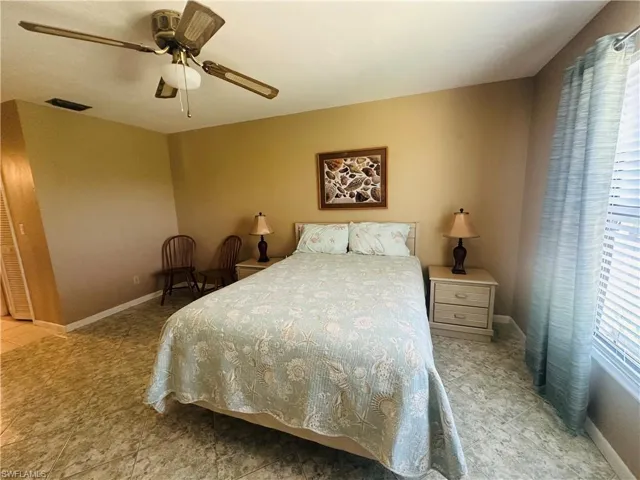 Bedroom featuring tile patterned flooring, a ceiling fan, and baseboards