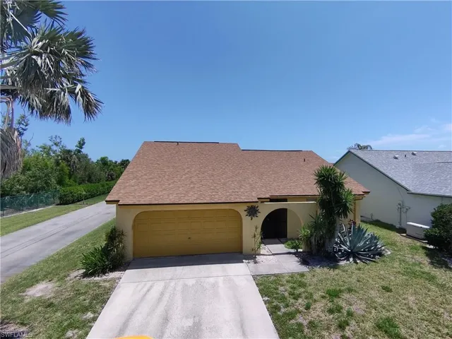 View of front of property with driveway, stucco siding, a garage, and a shingled roof