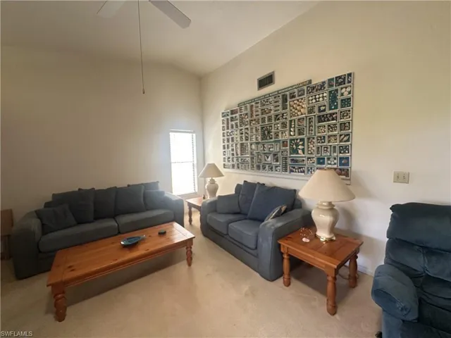 Living area featuring carpet and ceiling fan