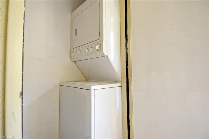 Laundry room with stacked washer and clothes dryer
