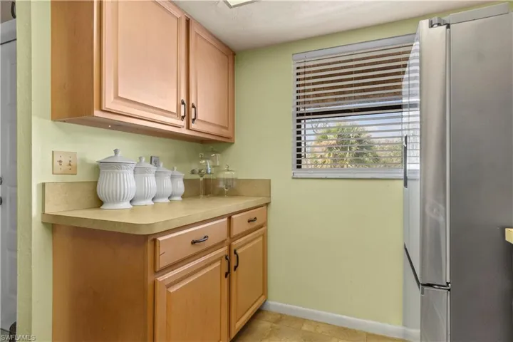 Kitchen with light tile patterned flooring and stainless steel fridge