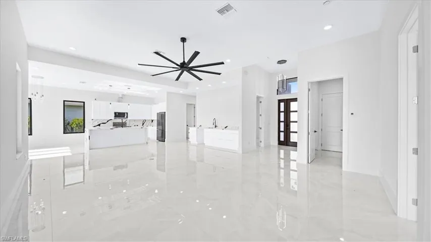 Unfurnished living room with light marble finish flooring, french doors, recessed lighting, and ceiling fan