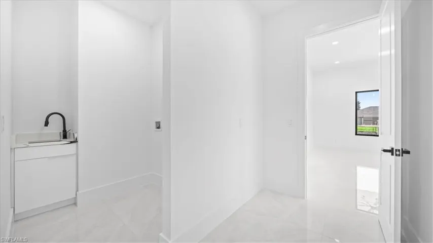 Bathroom featuring vanity, light marble finish flooring, and recessed lighting