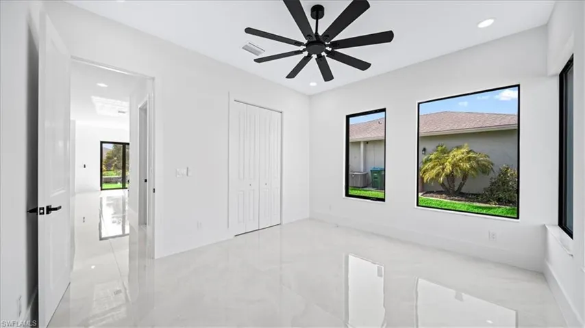 Unfurnished bedroom featuring light marble finish floors, a ceiling fan, a closet, and recessed lighting