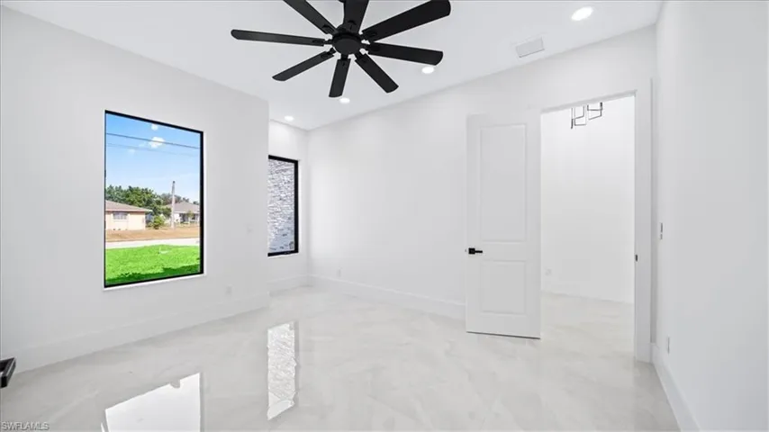 Spare room featuring recessed lighting, light marble finish floors, and a ceiling fan
