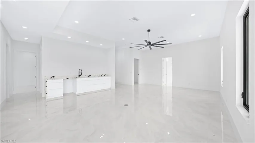 Unfurnished living room featuring light marble finish floors, recessed lighting, and ceiling fan