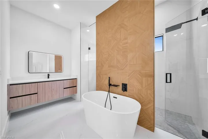 Bathroom with tile patterned flooring, plus walk in shower, and vanity