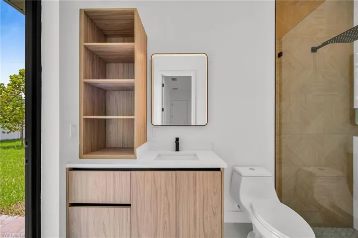 Bathroom with vanity, toilet, and a shower