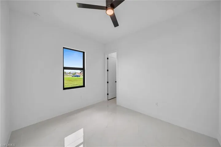 Empty room featuring tile patterned flooring and ceiling fan