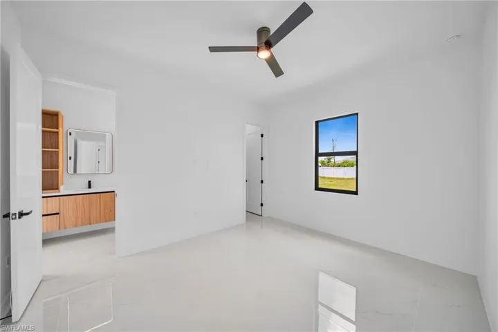 Tiled spare room featuring ceiling fan