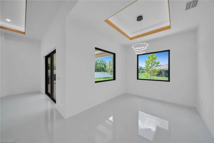 Tiled spare room featuring a raised ceiling