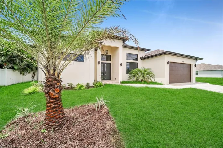 View of front of house with a garage and a front lawn