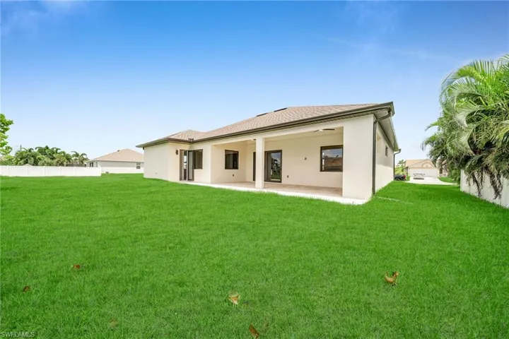 Back of property with a patio area and a lawn