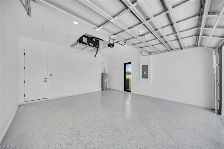 Garage featuring water heater and electric panel