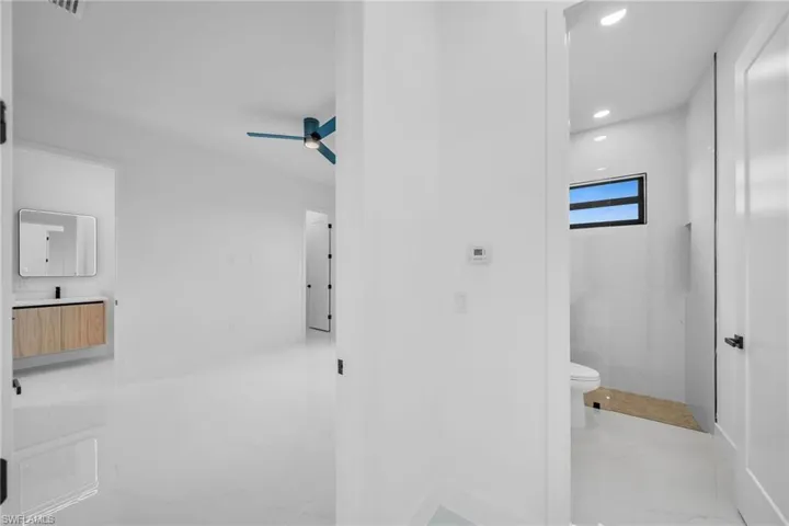 Bathroom featuring tile patterned flooring, toilet, and ceiling fan