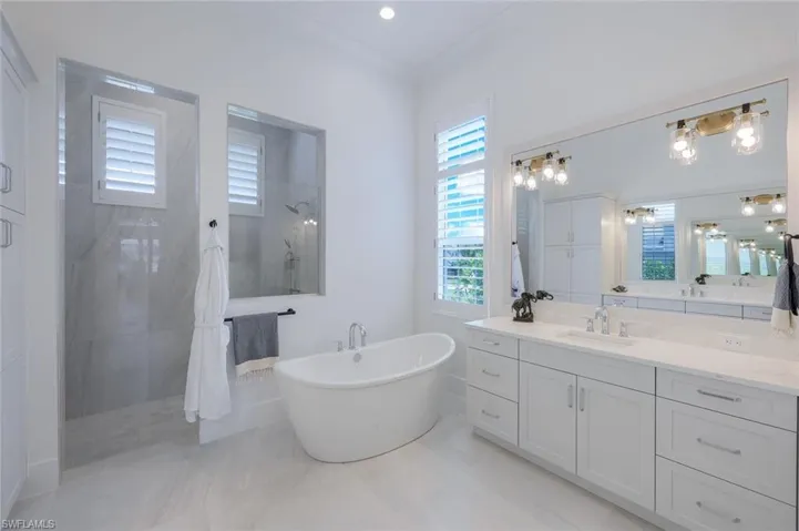 Bathroom featuring tile floors, plus walk in shower, and vanity